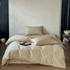 Beige bedding set on a bed with a minimal background