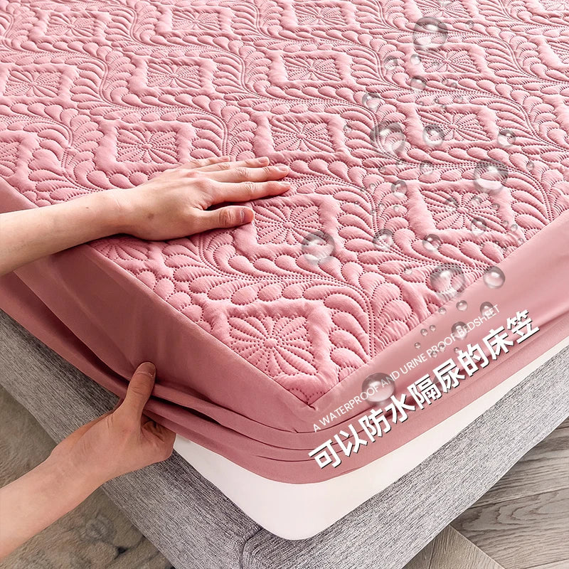 Pink quilted mattress cover with water droplets on a wooden floor.