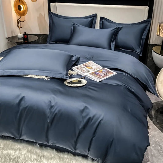 Blue bedding set on a bed with a nightstand and decor items in the background.