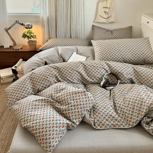 Bed with patterned comforter in a bedroom setting