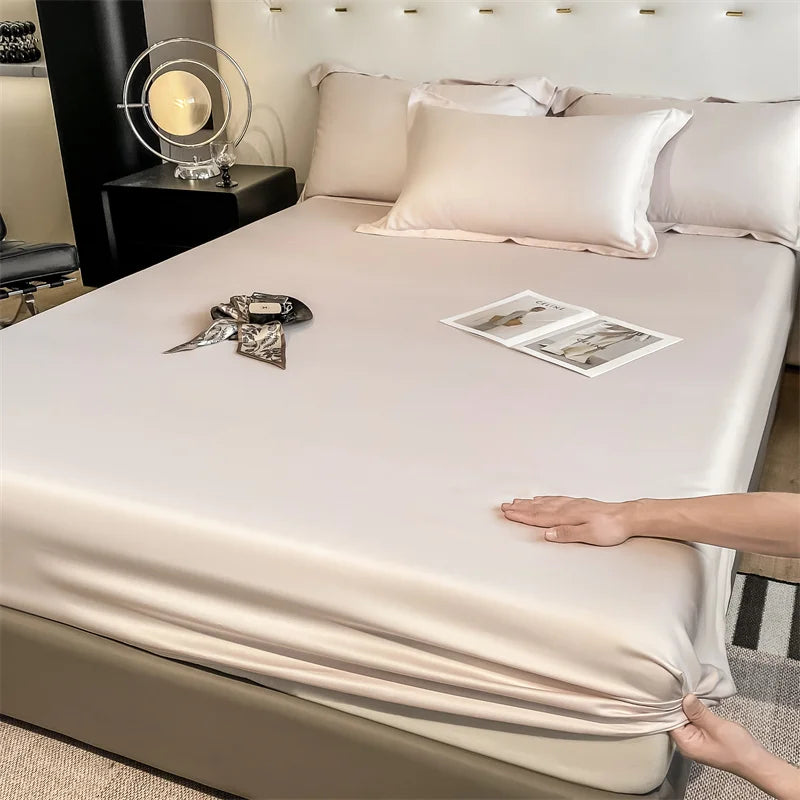 Person adjusting a fitted sheet on a bed in a bedroom setting.