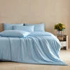 Light blue comforter on a bed with a minimal background