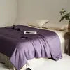 Bed with a purple comforter in a bedroom setting