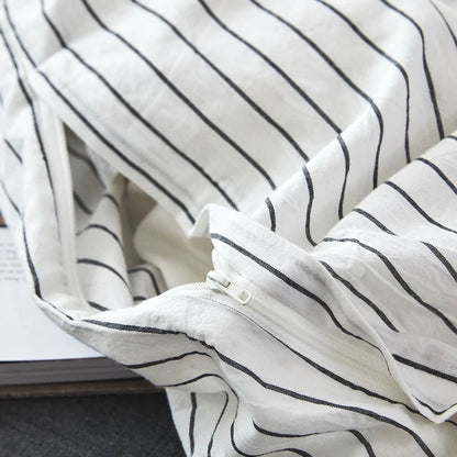 Close-up of a white fabric with black stripes on a surface.