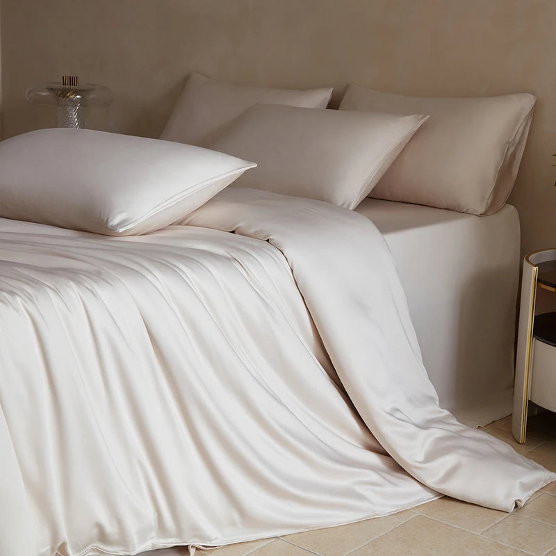 Neatly made bed with white bedding and pillows in a softly lit room.