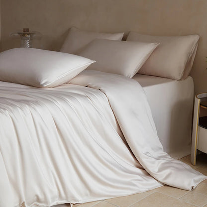 Neatly made bed with white bedding and pillows in a softly lit room.