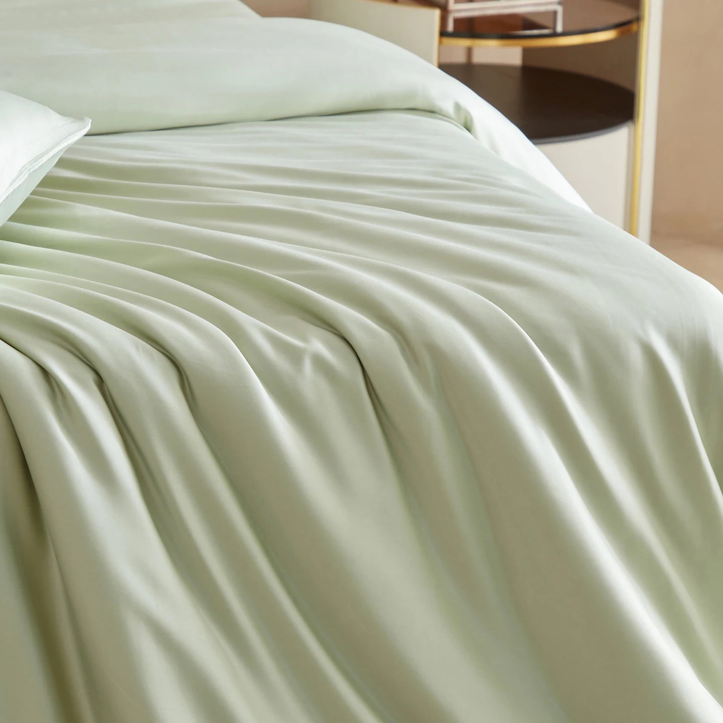 Light green comforter on a bed in a bedroom setting