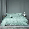 Light green bedding set on a bed with a neutral background