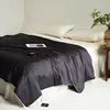 Bed with black bedding in a bedroom setting