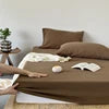 Bedding set with brown comforter and pillows on a bed.