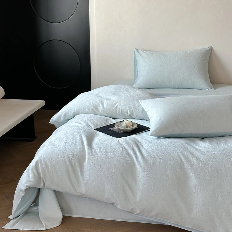 Neatly made bed with white bedding and pillows in a bedroom setting.