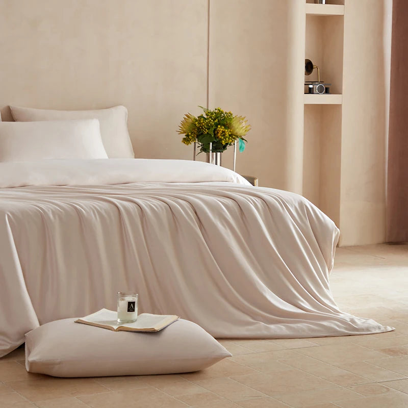 Neatly made bed with white bedding in a softly lit bedroom.
