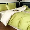 Green bedspread on a bed with pillows in a bedroom setting