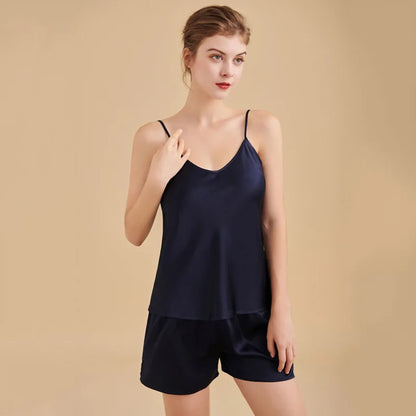 Woman wearing a navy blue satin camisole and shorts set on a beige background