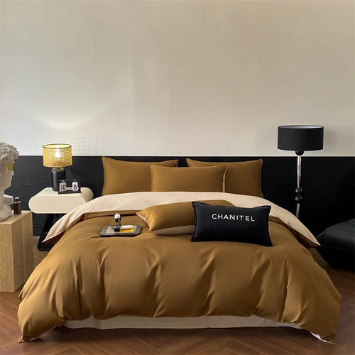 Bedroom with brown bedding and 'CHANITEL' pillow, nightstands with lamps.