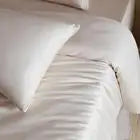 White comforter on a bed with a blurred background