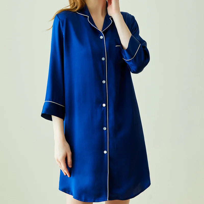 Blue nightshirt with white trim worn by a person on a plain background