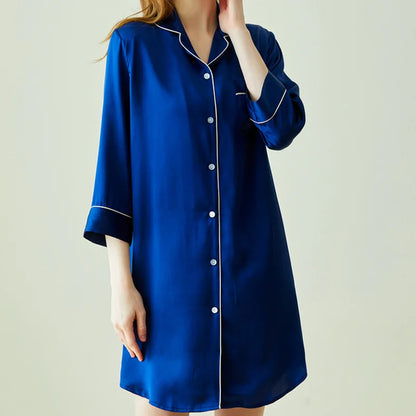 Blue nightshirt with white trim worn by a person on a plain background
