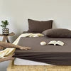 Bedding set with brown comforter and white pillows on a bed.
