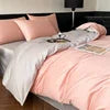 Pink and gray bedding set on a bed with pillows.