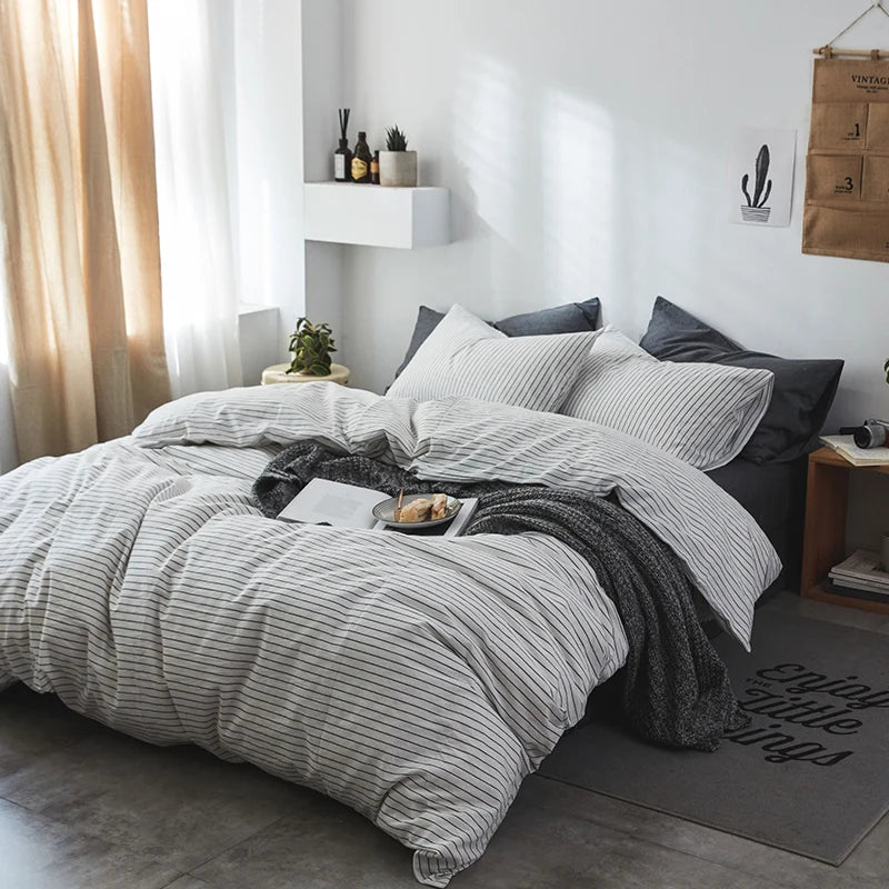 Bedroom with gray striped bedding and decorative elements.