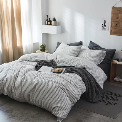 Bedroom with gray striped bedding and decorative elements.