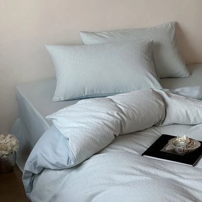 Light blue bedding set on a bed with a neutral background