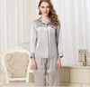Woman in a gray outfit standing in a room with white walls and furniture.