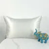 Silky pillowcase on a bed with a blue elephant toy.