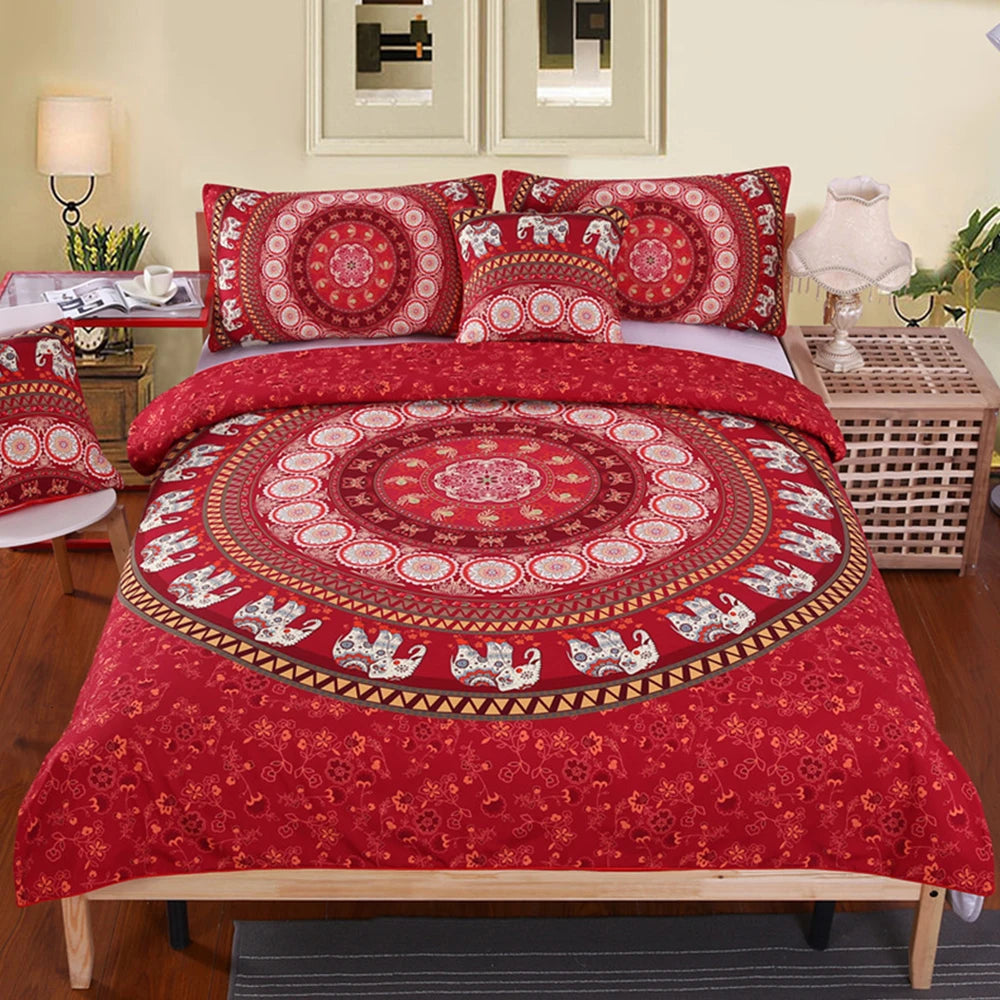Red patterned bedspread with elephants on a bed in a bedroom setting.