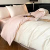 Bed with pink bedding and white comforter in a bedroom setting