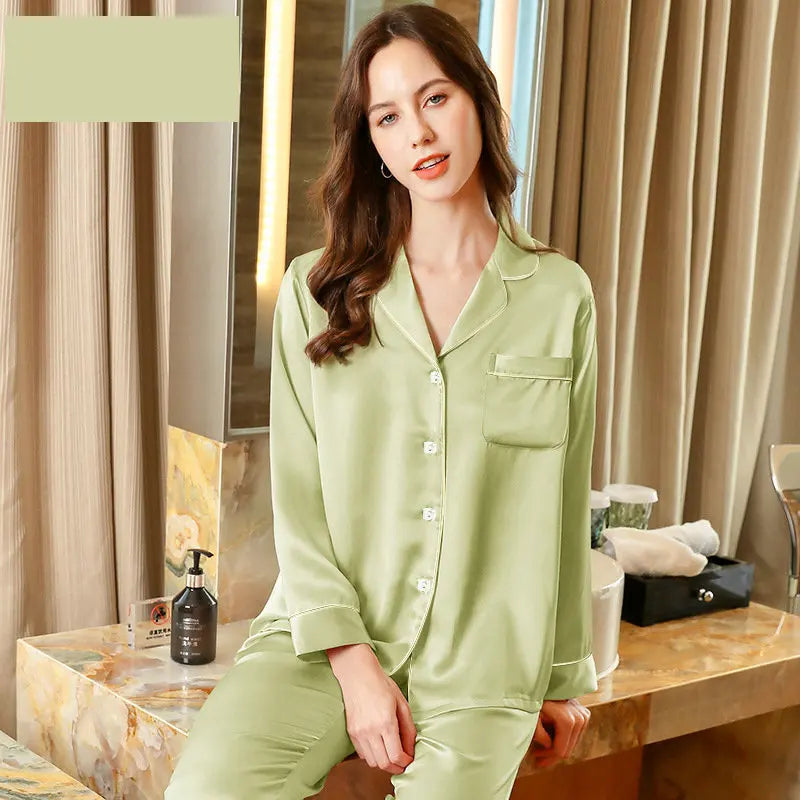 Woman wearing green pajamas sitting on a bed in a bedroom setting.