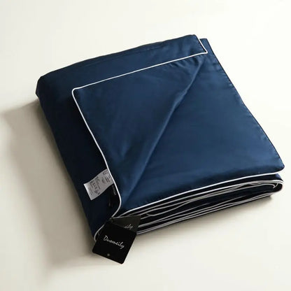 Folded navy blue fabric with white piping on a light beige background