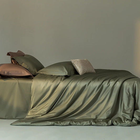 Green satin bedding set on a bed with a neutral background