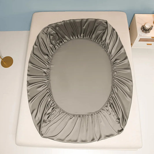 Gray fitted seat cover on a toilet against a light blue wall.