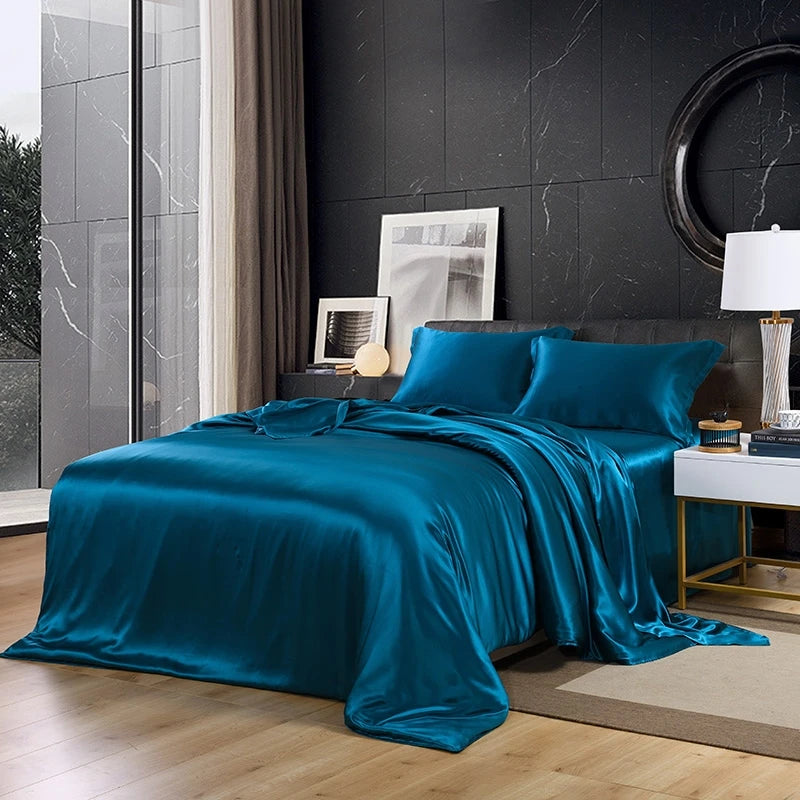 Teal satin bedding set on a bed in a modern bedroom.
