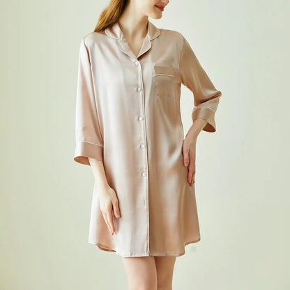 Woman wearing a beige satin nightshirt against a plain background