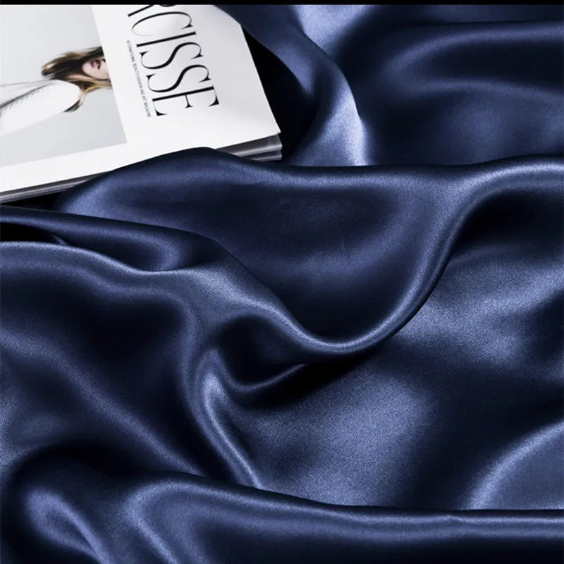 Navy blue satin fabric with a magazine in the background