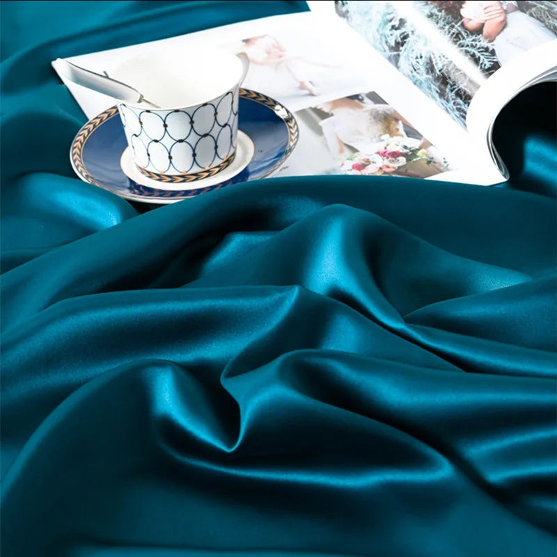 Teal satin fabric with a cup and saucer on top