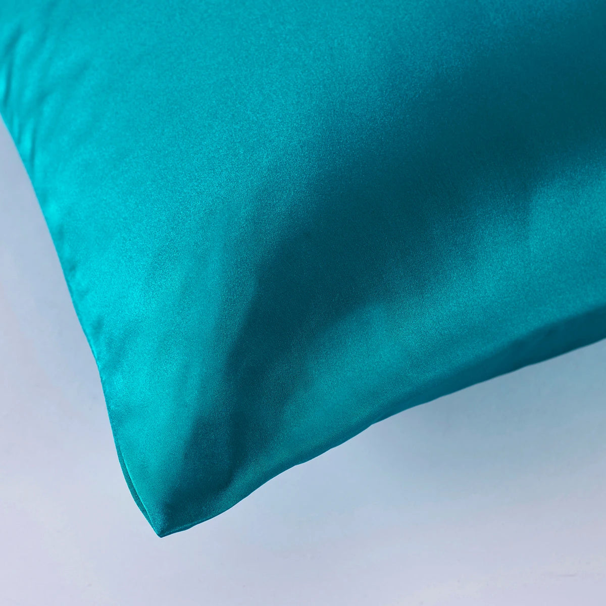 Teal pillow on a light gray background