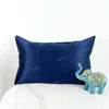 Blue pillowcase on a white pillow with an elephant toy in the corner