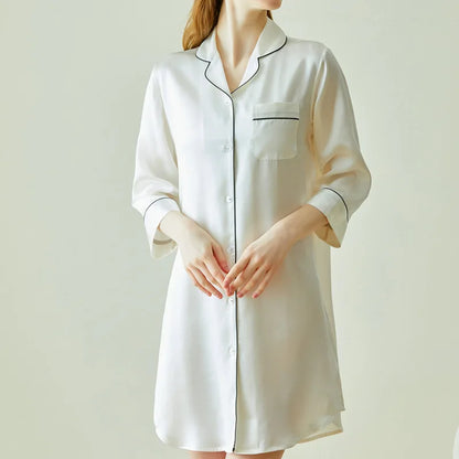 White nightshirt worn by a person on a plain background