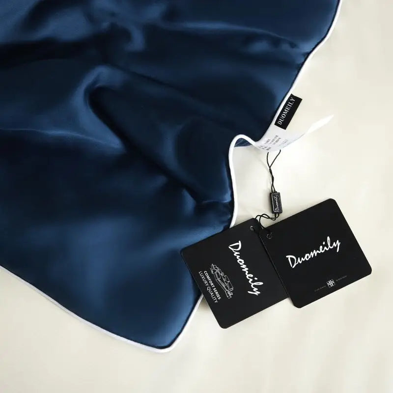 Navy blue fabric with Duomily brand tags on a white background