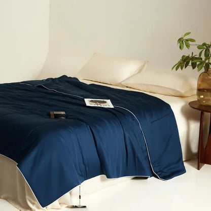 Blue blanket on a bed with a neutral background