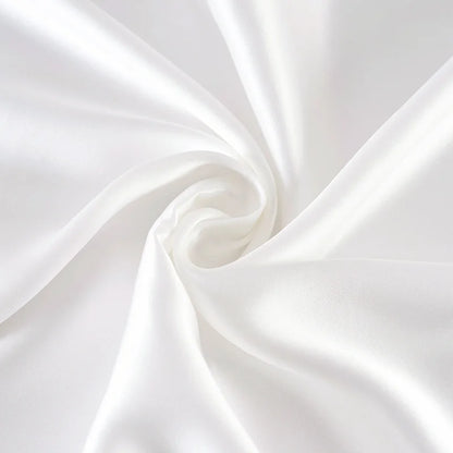 Close-up of white satin fabric with a subtle swirl pattern