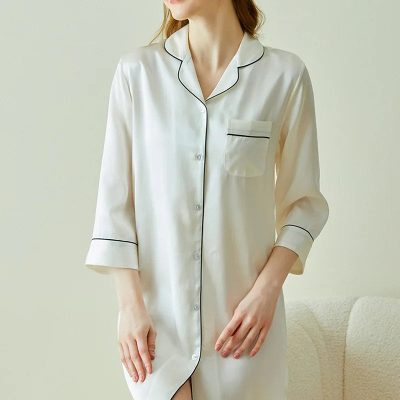 White satin nightshirt with black piping on a neutral background