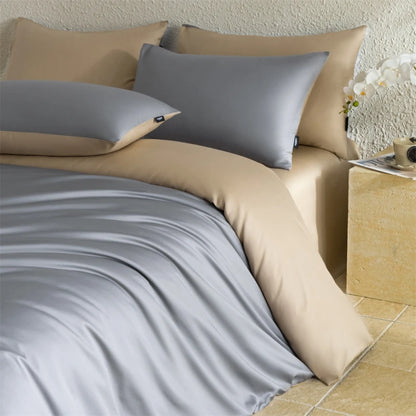 Beige and gray bedding set on a bed with a side table in the background.
