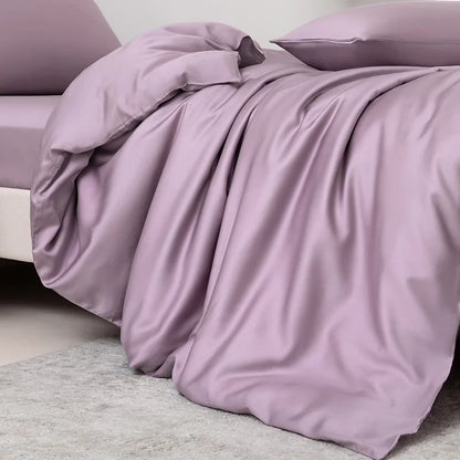 Purple bedding set on a bed with a neutral background