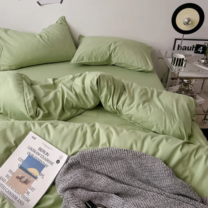 Green bed with pillows and a book on a nightstand in a bedroom setting.