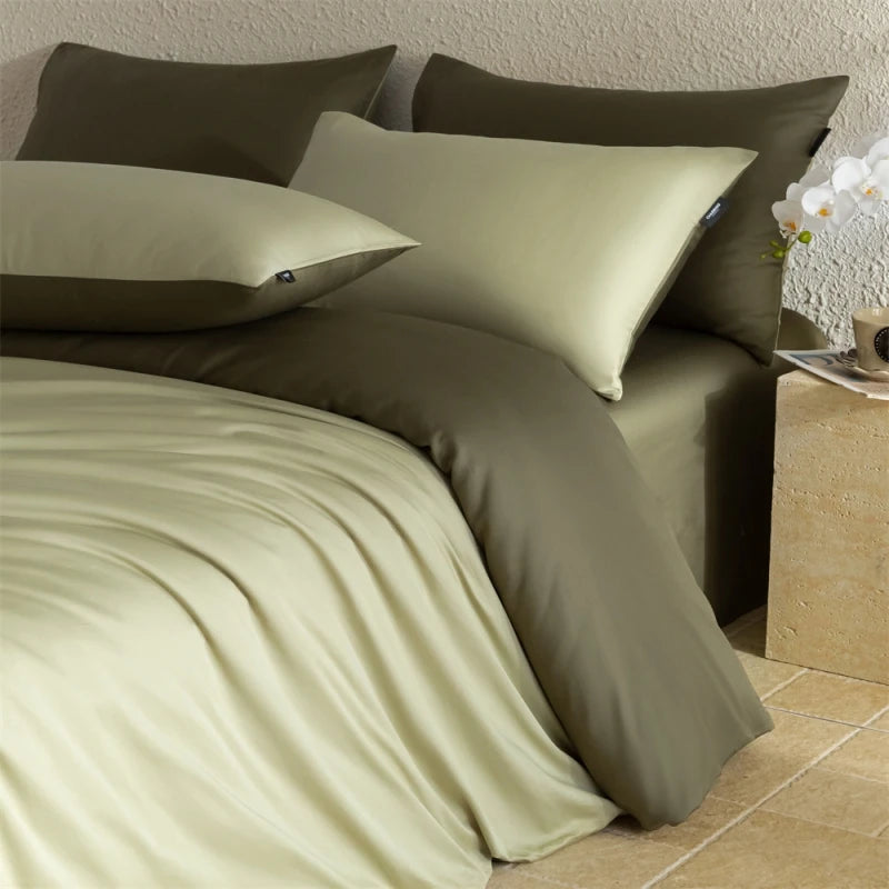 Green bedding set with pillows on a bed in a bedroom setting.